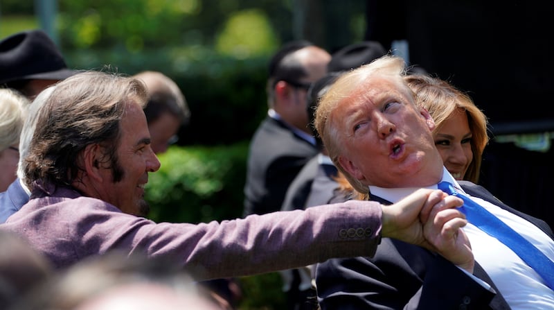 U.S. President Donald Trump clasps hands with Journey keyboardist Jonathan Cain during a National Day of Prayer Service at the White House in Washington, U.S., May 2, 2019.  REUTERS/Kevin Lamarque
