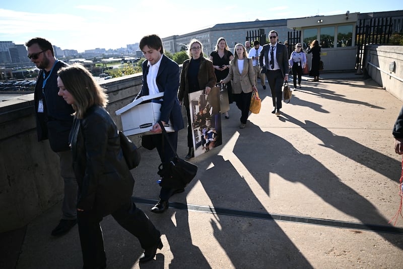 Reporters carry their belongings from the Pentagon in Washington, DC, on October 15, 2025 after US and international news outlets including The New York Times, AP, AFP and Fox News declined to sign new restrictive Pentagon media rules, and were stripped of their press access credentials. The new rules come after the Defense Department restricted media access inside the Pentagon, forced some outlets to vacate offices in the building and drastically reduced the number of briefings for journalists. (Photo by Brendan SMIALOWSKI / AFP) (Photo by BRENDAN SMIALOWSKI/AFP via Getty Images)