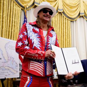 U.S. President Donald Trump, accompanied by entertainer Kid Rock, signs an executive order in the Oval Office of the White House on March 31, 2025 in Washington, DC.
