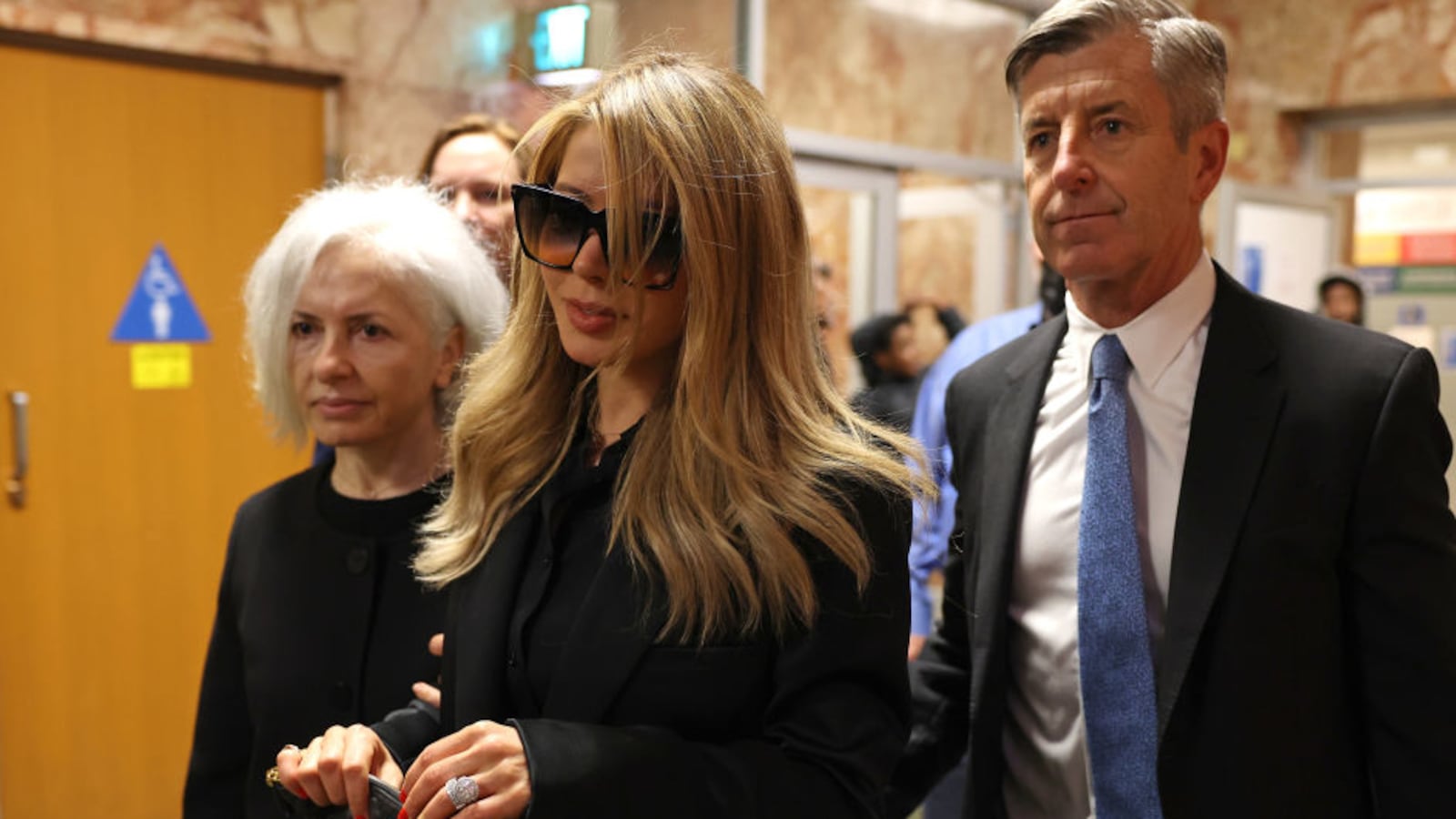 Khazar Elyassnia, wearing glasses, walks into a San Francisco courtroom.