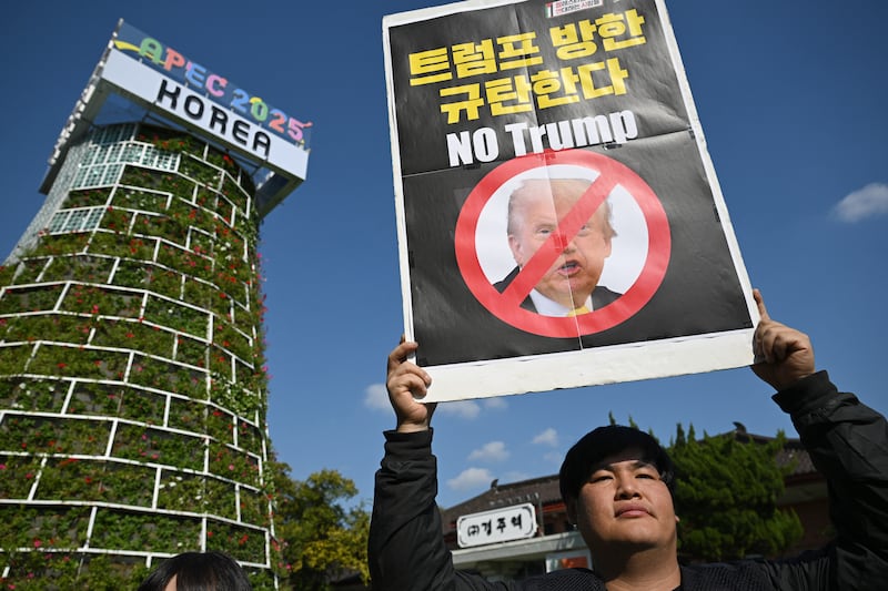 A South Korean protester holds a placard reading "No Trump."