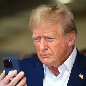MIAMI, FLORIDA - MAY 05: Donald Trump talks on the phone in the McLaren garage prior to the F1 Grand Prix of Miami at Miami International Autodrome on May 05, 2024 in Miami, Florida. (Photo by Clive Mason/Getty Images)