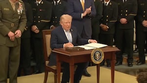 President Donald Trump sits to sign an executive order preserving the Army vs. Navy Game timeslot on March 20, 2026.