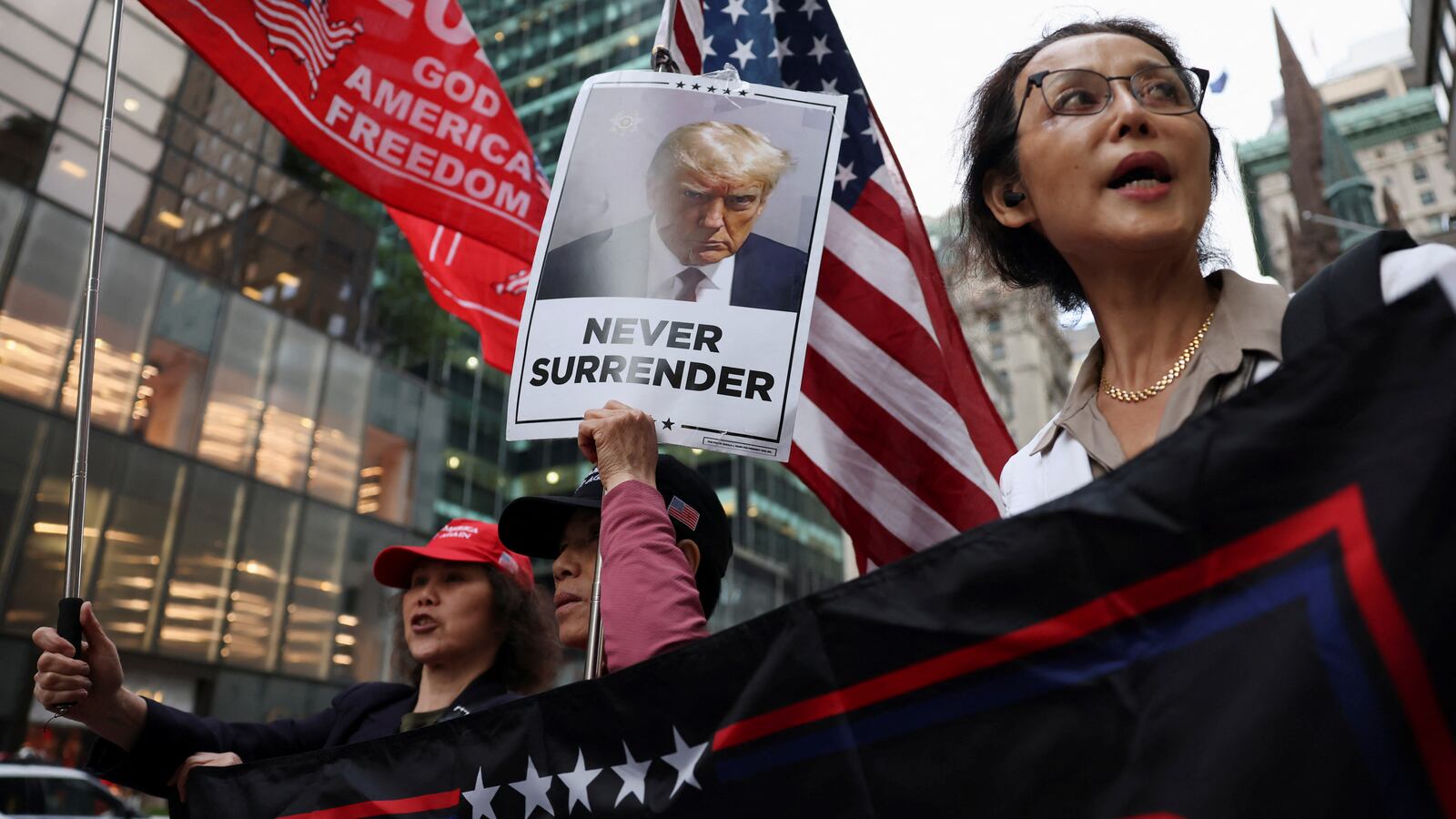 Supporters hold placards and flags following the announcement of the verdict in former U.S. President Donald Trump's criminal trial