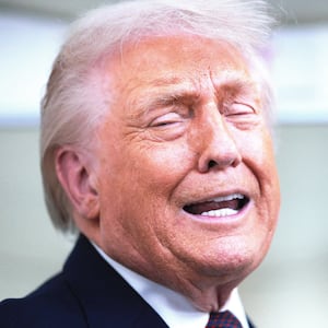 U.S. President Donald Trump speaks to reporters on board Air Force One