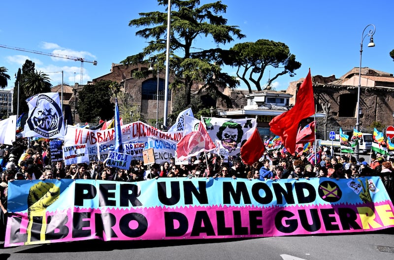 Particpiants walk behind a banner 'for a world free of war' during a demonstration against the Middle East war entitled "No Kings", in Rome on March 28, 2026. (Photo by Tiziana FABI / AFP via Getty Images)