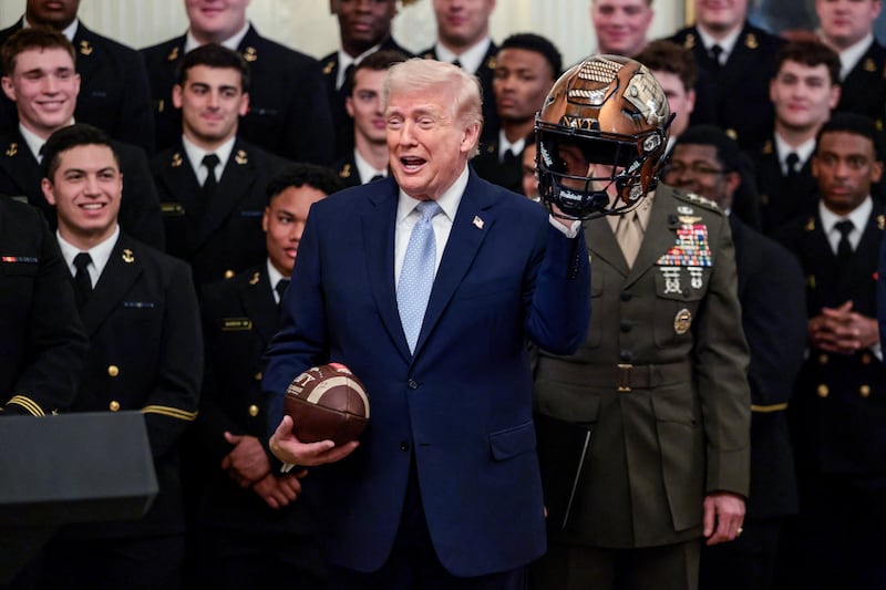U.S. President Donald Trump holds a football and a helmet during a presentation of the Commander-in-Chief's trophy to the U.S. Navy Midshipmen football team of the United States Naval Academy, at the White House in Washington, D.C., U.S., March 20, 2026. REUTERS/Evelyn Hockstein