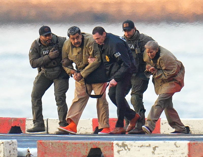 Nicolas Maduro and his wife, Cilia Flores, are seen in handcuffs after landing at a Manhattan helipad, escorted by heavily armed Federal agents as they make their way into an armored car en route to a Federal courthouse in Manhattan on January 5, 2026 in New York City.