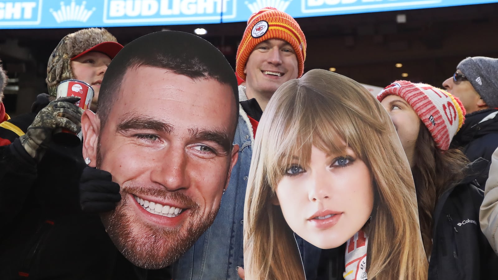 Fans hold large pictures of Travis Kielce and Taylor Swift