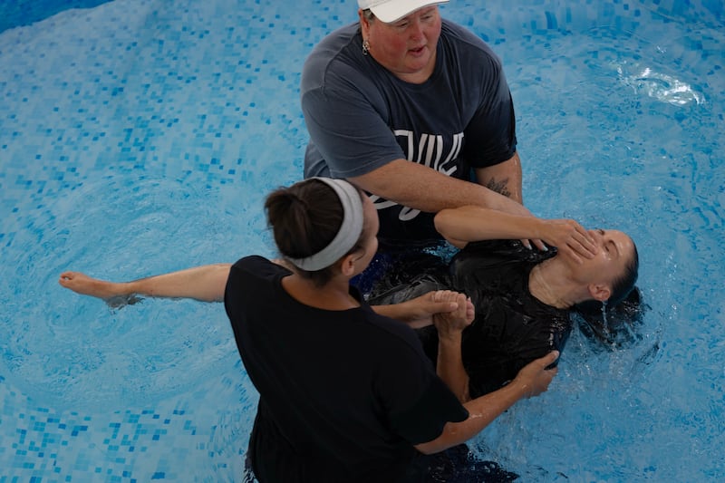 WASHINGTON,DC - JULY 1: Molly Collins, front, and Tiffany Couch, back, perform a baptism for Laura Oxendine during the Great American State Fair at David's Tent in Washington, D.C., July 1, 2026. The founding ideals celebrated by Americans on the 250th anniversary hold significant meaning with the visitors of faith, who believe the nation is a product of Christianity.