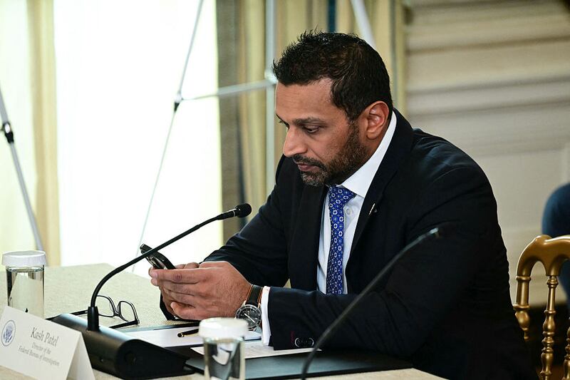 FBI Director Kash Patel looks at his phone during a law enforcement roundtable in the State Dining Room of the White House on October 23, 2025 in Washington, DC.