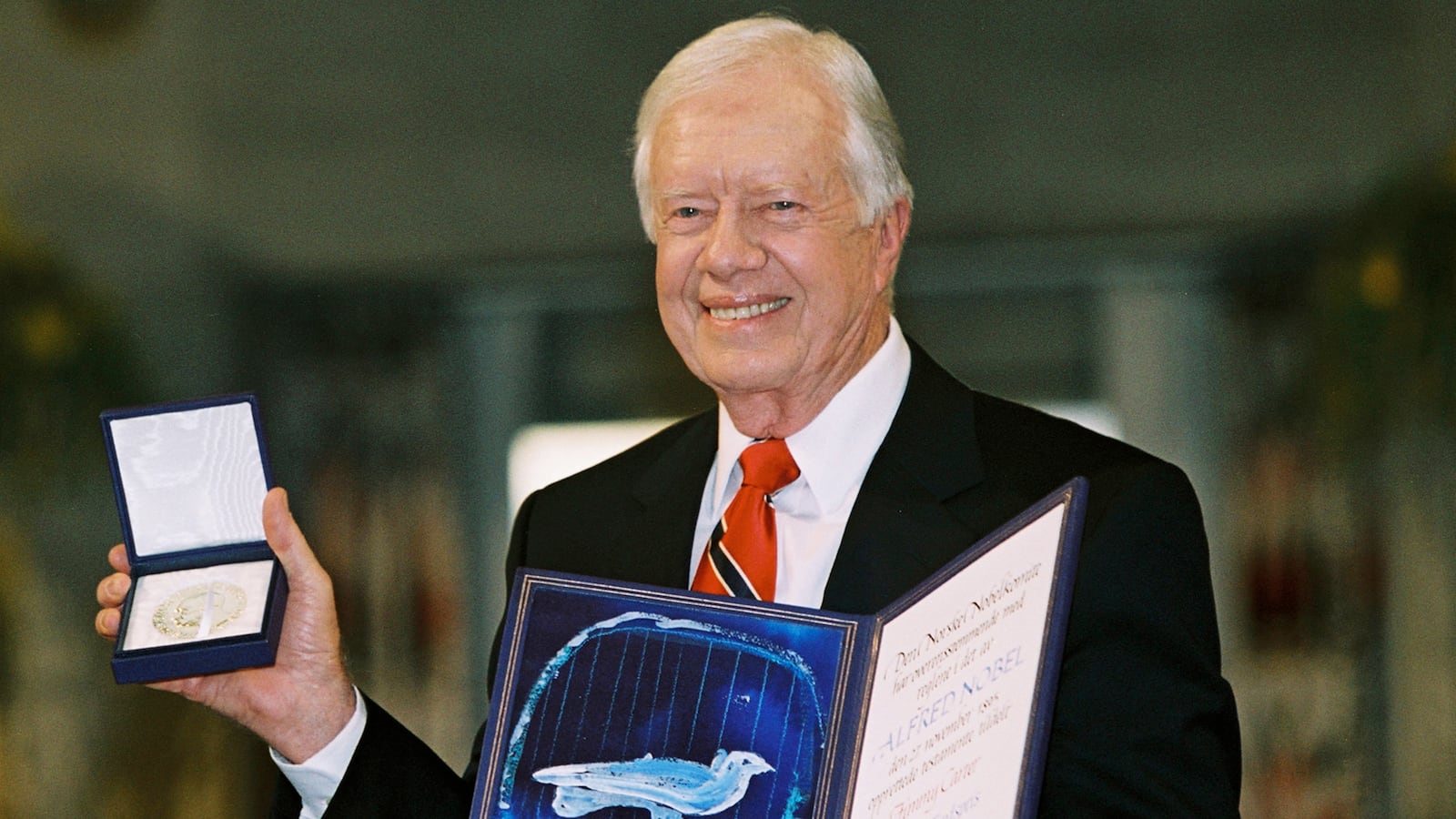 Former US President Jimmy Carter holds up his Nobel Peace Prize December 10, 2002 in Oslo, Norway.