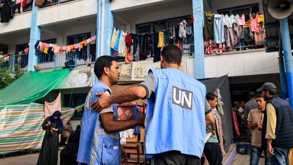 Workers of the UNRWA) agency talk together in the playground of an UNRWA-run school that has been converted into a shelter for displaced Palestinians in Khan Yunis in the southern Gaza Strip on October 25, 2023.