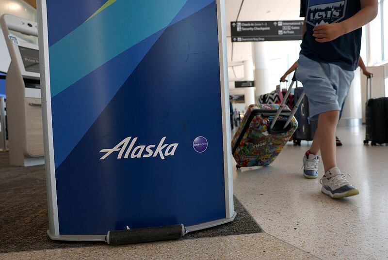 SAN FRANCISCO, CALIFORNIA - JUNE 04: The Alaska Airlines logo is displayed in front of a ticket counter at San Francisco International Airport on June 04, 2025 in San Francisco, California. Alaska Airlines is delaying the delivery of two Embraer E175 planes from Brazilian manufacturer Embraer due to tariffs imposed by the Trump administration, and says it will not accept additional costs imposed by tariffs. (Photo by Justin Sullivan/Getty Images)