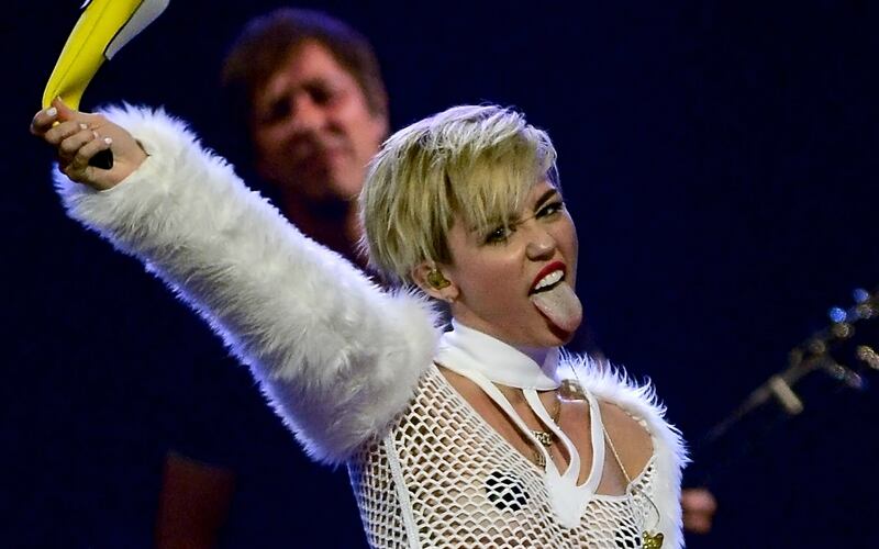 articles/2013/09/24/miley-cyrus-gets-naked-for-rolling-stone-the-voice-ratings-surprise/Miley-Cyrus-i-heart-radio-plus-banana-tease_lnznfo