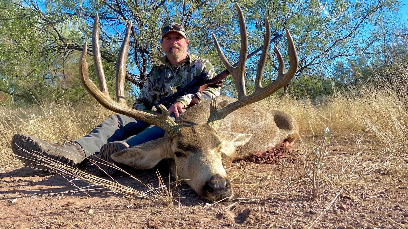 Image of Asher Watkins posing with a Sonoran Desert mule deer.