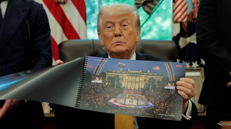 President Donald Trump shows an image of the White House with the Octagon, as he holds an event with UFC fighters Justin Gaethje and Ilia Topuria, in the Oval Office at the White House in Washington, D.C., U.S., May 6, 2026.