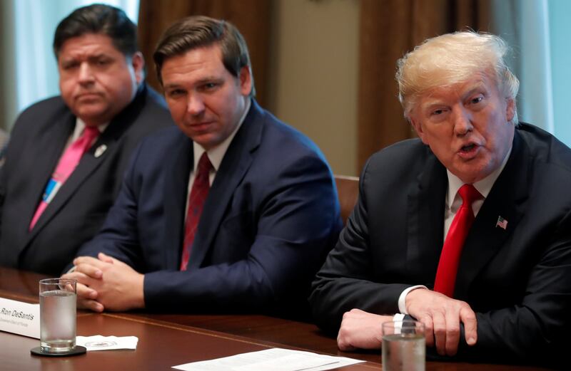 Pritzker, alongside Florida Gov. Ron DeSantis and Trump, during a meeting with governors at the White House in 2018—Pritzker and Trump are now going to war over Trump’s threats to deploy the National Guard in Chicago.