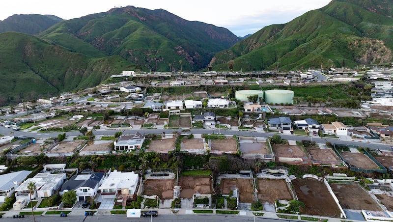 An aerial view shows empty lots and new homes under construction in Pacific Palisades, California on January 5, 2026. Altadena was hardest hit by the fires that ravaged parts of the sprawling US metropolis in January 2025. Thousands of homes were destroyed and 19 people died in the town -- compared to 12 killed in the upscale Pacific Palisades neighborhood. (Photo by JOSH EDELSON / AFP via Getty Images)