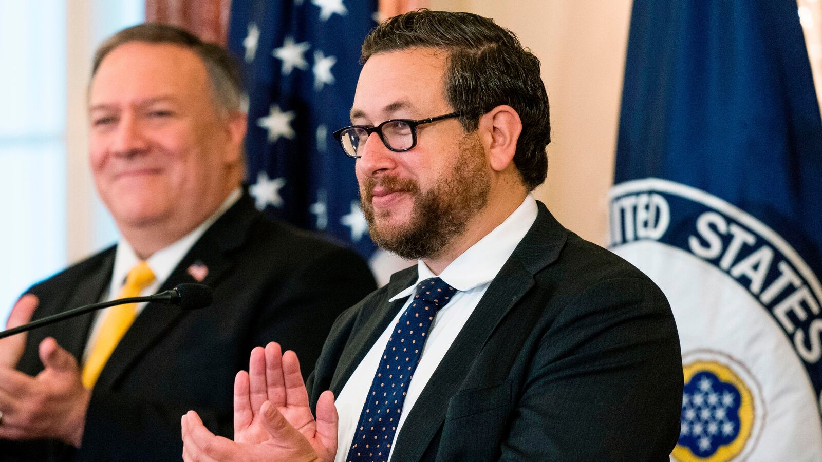 US Citizenship and Immigration Services (USCIS) Deputy Director for Policy Joseph Edlow,(R) and Secretary of State Mike Pompeo, applaud and congratulate new US citizens during a naturalization ceremony hosted by the USCIS at the State Department in Washington, DC, on October 22, 2020.