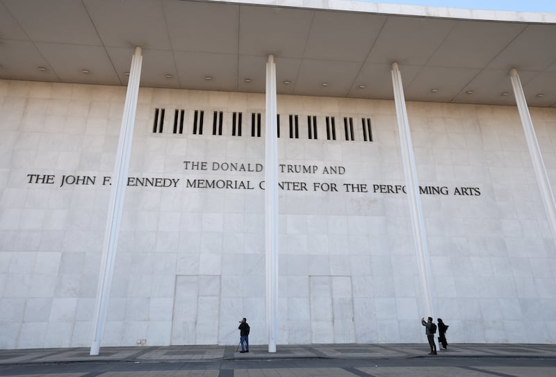 People stand outside the John F. Kennedy Center for the Performing Arts, with U.S. President Donald Trump's name added to its facade, a day after its board announced it would rename the institution The Donald J. Trump and The John F. Kennedy Memorial Center for the Performing Arts, in Washington, D.C., U.S., December 19, 2025. REUTERS/Kevin Lamarque