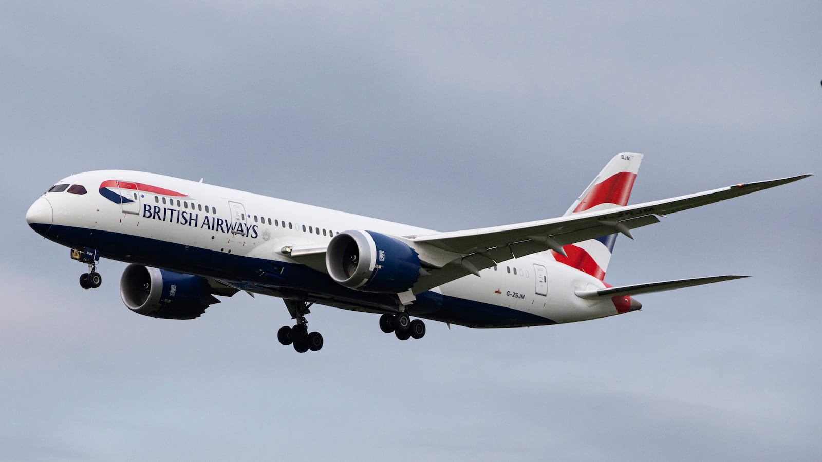 British Airways Boeing 787-8 Dreamliner aircraft spotted flying on final approach over the roofs of the houses of Myrtle avenue for landing at London Heathrow Airport LHR in the UK.