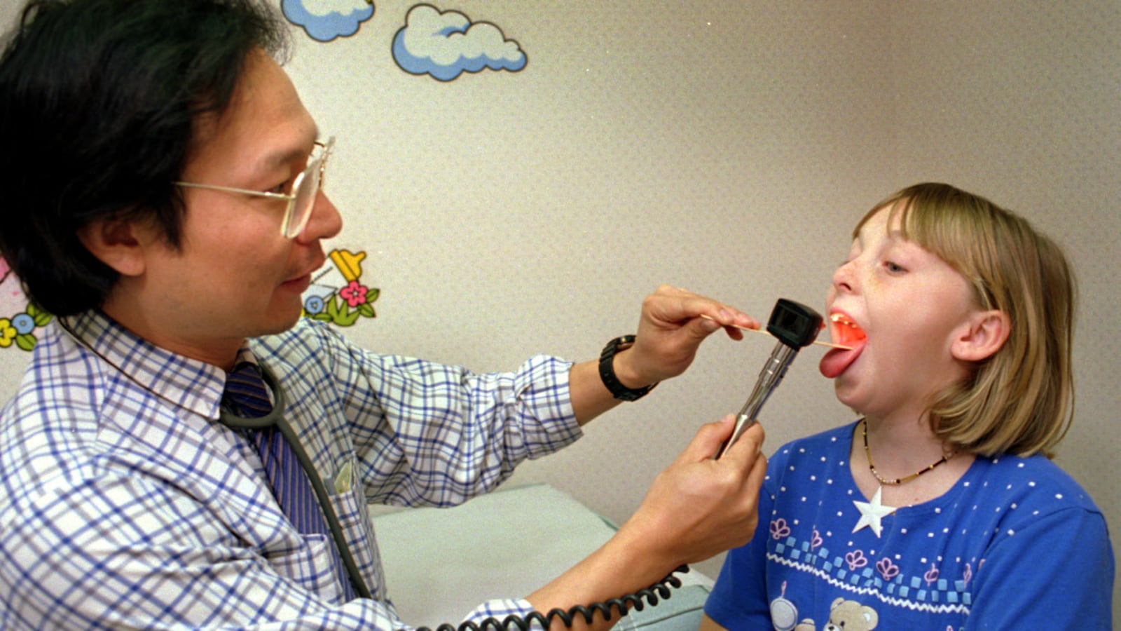 Stanley Su, M.D. checks Melanie Minetti,10 , for strep throat at Sierra Vista Family Care in Simi Valley.