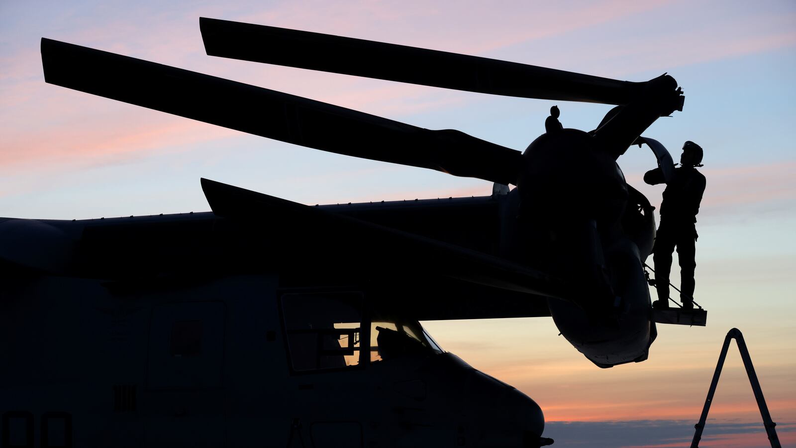 A U.S. Marine maintenance personal checks an MV-22B Osprey aboard the USS Bataan, a U.S. Navy Wasp-class amphibious assault ship.