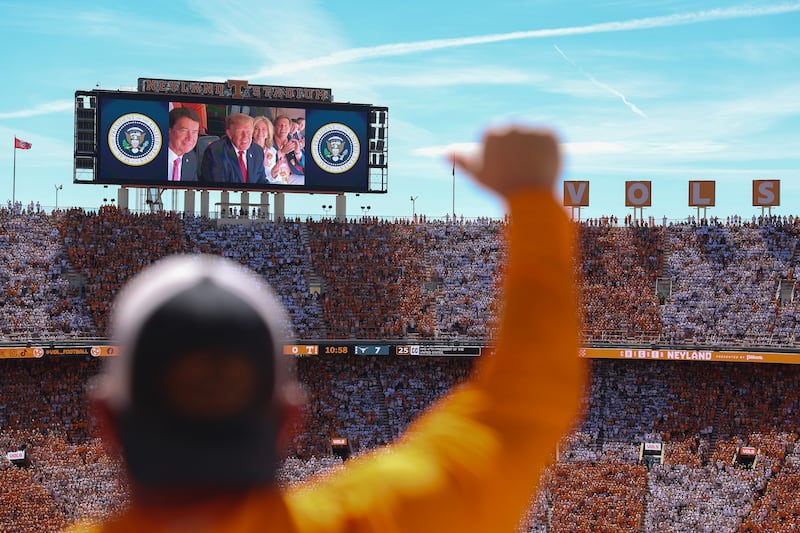 President Donald Trump, Sen. Bill Hagerty and Sen. Marsha Blackburn appear on a video screen while attending the Texas-Tennessee football game.