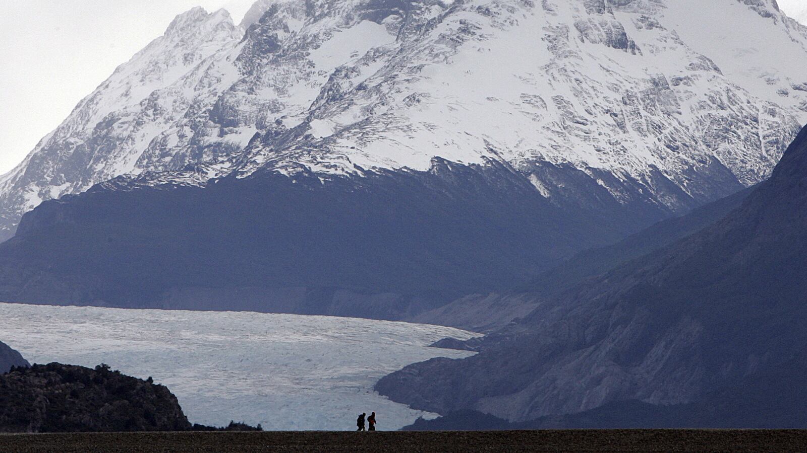 A couple of tourists walk in Torres del Paine National Park in Patagonia, Chile, 10 November 2007. AFP PHOTO/ Rodrigo ARANGUA (Photo credit should read RODRIGO ARANGUA/AFP via Getty Images)