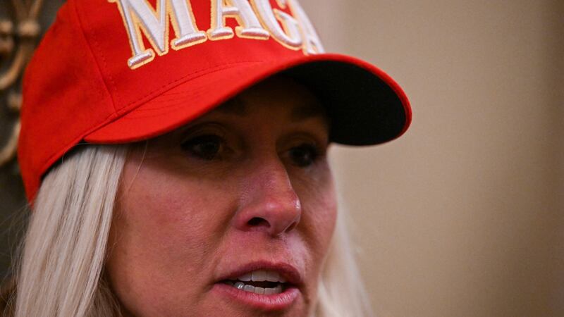 Marjorie Taylor Greene speaks to the press wearing a red "MAGA" hat at the U.S. Capitol in Washington, DC.