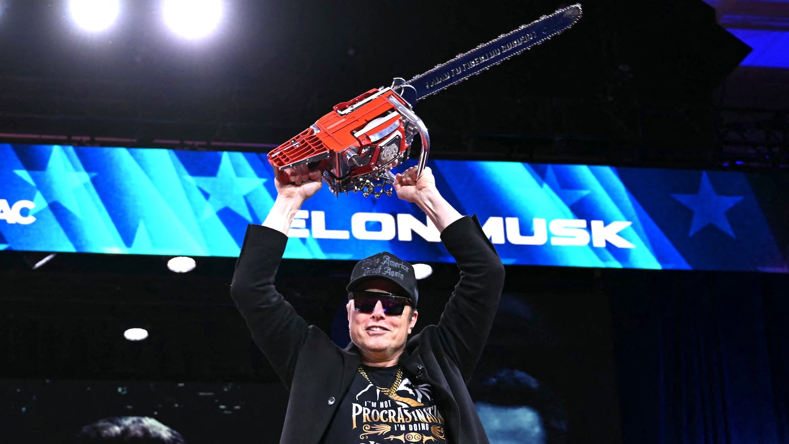 Elon Musk holds a chainsaw reading "Long live freedom, damn it" during the annual Conservative Political Action Conference (CPAC) at the Gaylord National Resort & Convention Center at National Harbor in Oxon Hill, Maryland, on February 20, 2025.