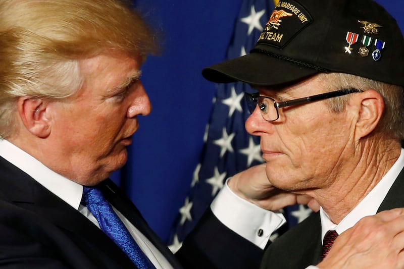 U.S. President Donald Trump embraces veteran Max Morgan during an event to acknowledge the 50th anniversary of the war in Vietnam, as part of a visit to Danang, Vietnam November 10, 2017. REUTERS/Jonathan Ernst