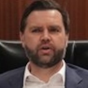 JD Vance sitting at the head of a table in a wood-lined room with his seal and Tulsi Gabbard and Scott Bessent.