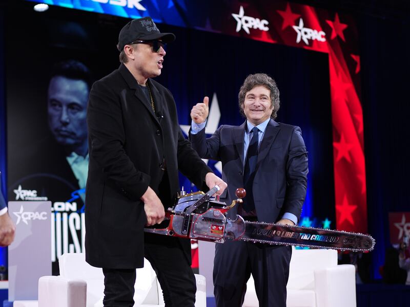 OXON HILL, MARYLAND - FEBRUARY 20: CEO of Tesla and SpaceX Elon Musk holds a chainsaw as he arrives on stage at the Conservative Political Action Conference (CPAC) at the Gaylord National Resort Hotel And Convention Center on February 20, 2025 in Oxon Hill, Maryland. The annual four-day gathering brings together conservative U.S. lawmakers, international leaders, media personalities and businessmen to discuss and champion conservative ideas. Musk was joined on stage by Argentine President Javier Milei, who gifted Musk the chainsaw he used as a prop while campaigning. (Photo by Andrew Harnik/Getty Images)