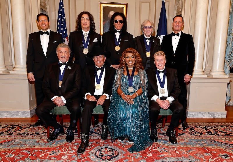 Secretary of State Marco Rubio, Paul Stanley, Gene Simmons, Peter Criss, Amb. Richard Grenell and (Front Row L-R) Sylvester Stallone, George Strait, Gloria Gaynor, Michael Crawford pose for the honoree class photo at the 48th Kennedy Center Honors Medallion Reception