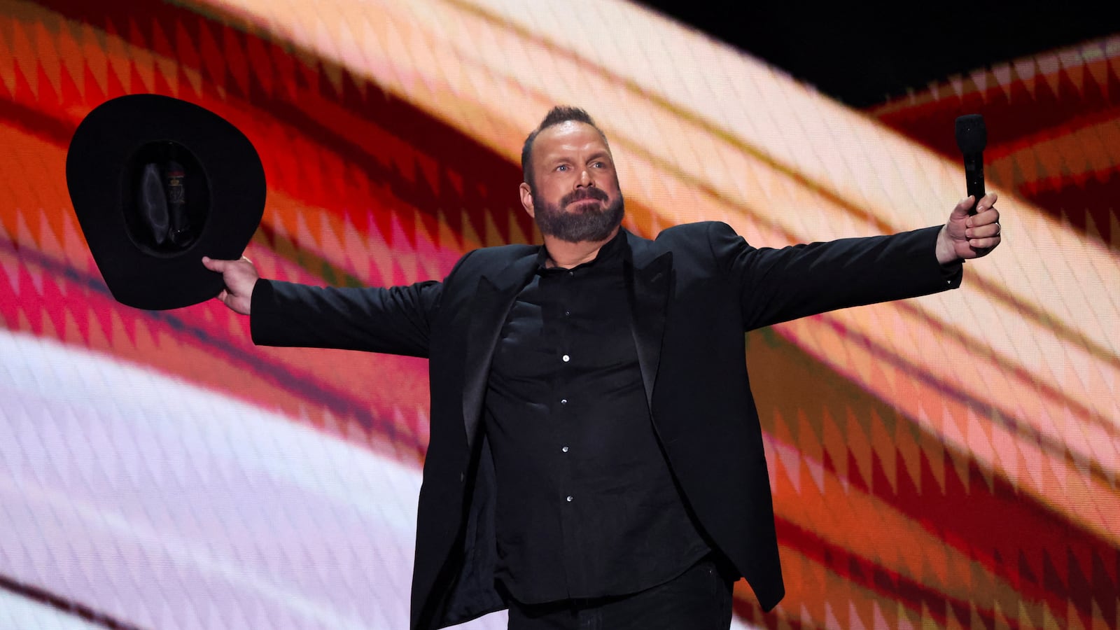 Garth Brooks on stage with his arms spread to his side.