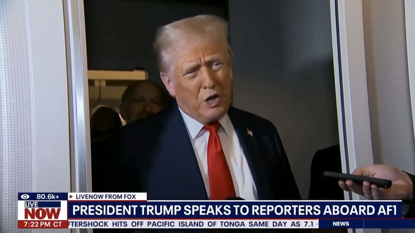 Trump addresses reporters aboard Air Force One.