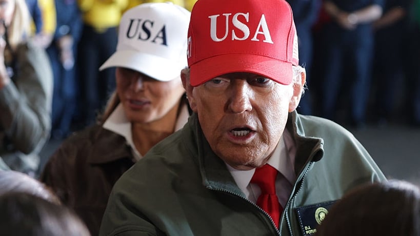 U.S. President Donald Trump and First Lady Melania Trump greet people as they arrive on the USS George H.W. Bush aircraft carrier on October 5, 2025 off the eastern coast of the United States. President Trump is visiting Naval Station Norfolk in Virginia for a celebration of the 250th birthday of the U.S. Navy. (Photo by Alex Wong/Getty Images)