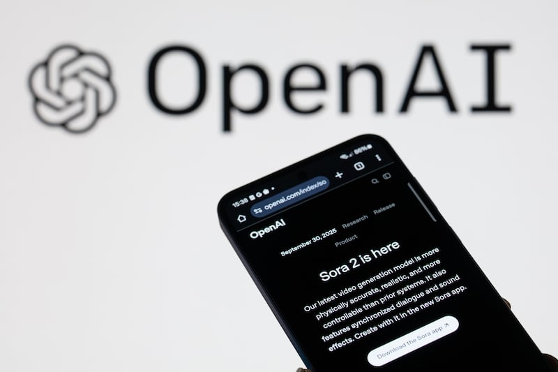The Sora 2 introduction is displayed on a mobile phone with the OpenAI company's branding seen in the background, in this photo illustration in Brussels, Belgium, on October 19, 2025.