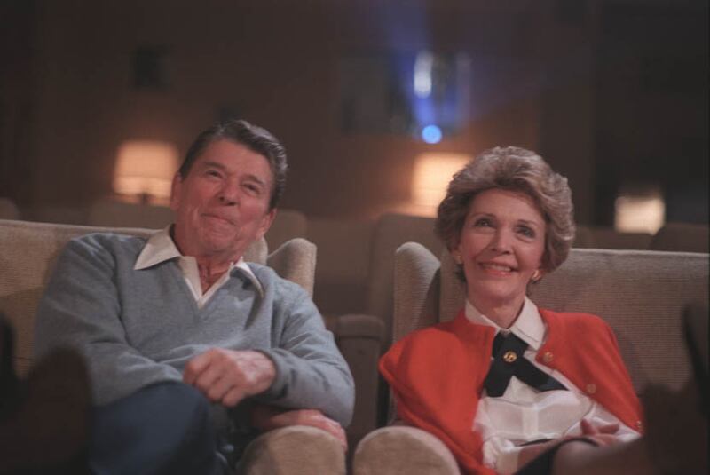 President Ronald Reagan and his wife, Nancy Reagan, watch a film in the White House Family Theater in 1986.