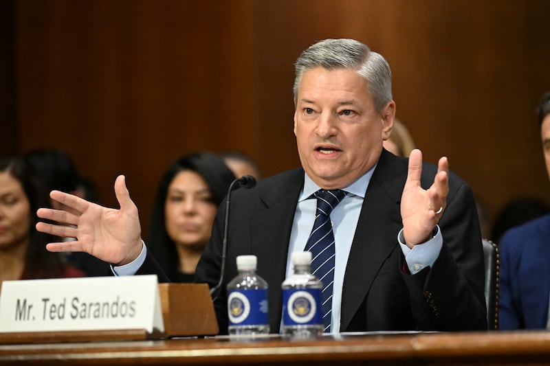 A man sits at a table while testifying at a congressional hearing.