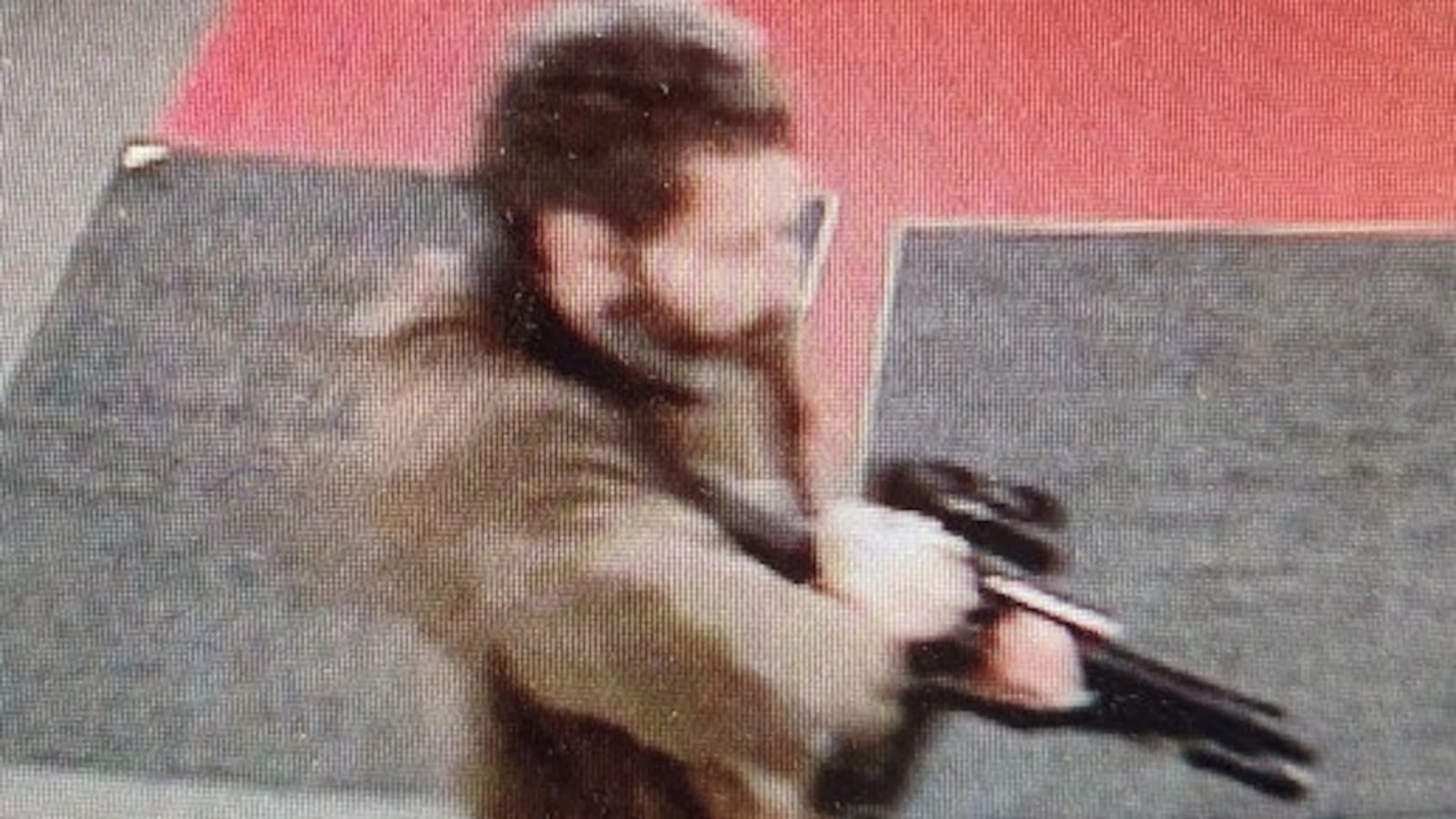 A man identified as a suspect by police points what appears to be a semiautomatic rifle in Lewiston, Maine, Oct. 25, 2023.