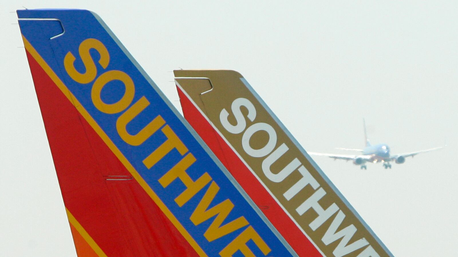 A Southwest Airlines plane (L) taxis past a second plane sitting at a gate as a third plane lands at Chicago's Midway Airport, May 20, 2005.