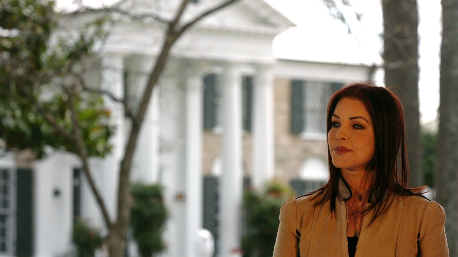 Priscilla Presley stands in front of Graceland