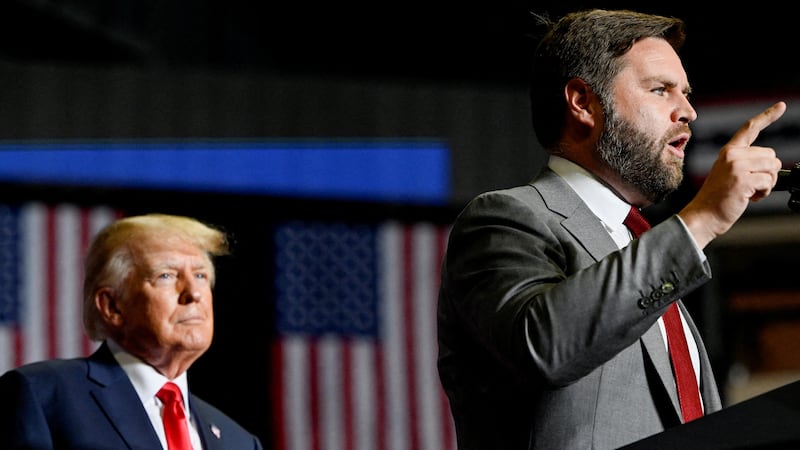 FILE PHOTO: Former U.S. president Donald Trump listens as JD Vance speaks during a rally in Youngstown, Ohio, U.S., September 17, 2022.  REUTERS/Gaelen Morse/File Photo