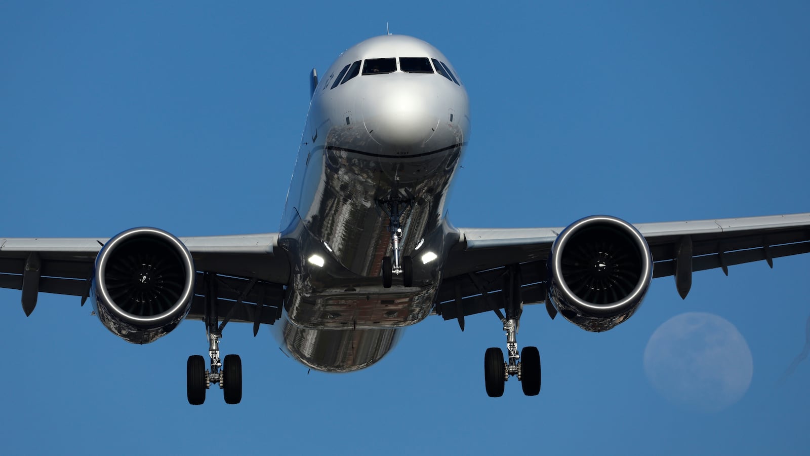 SAN DIEGO, CALIFORNIA - MAY 9: An United Airlines Airbus A321 approaches San Diego International Airport for a landing from Chicago as a full moon rises on May 9, 2025 in San Diego, California. (Photo by Kevin Carter/Getty Images)