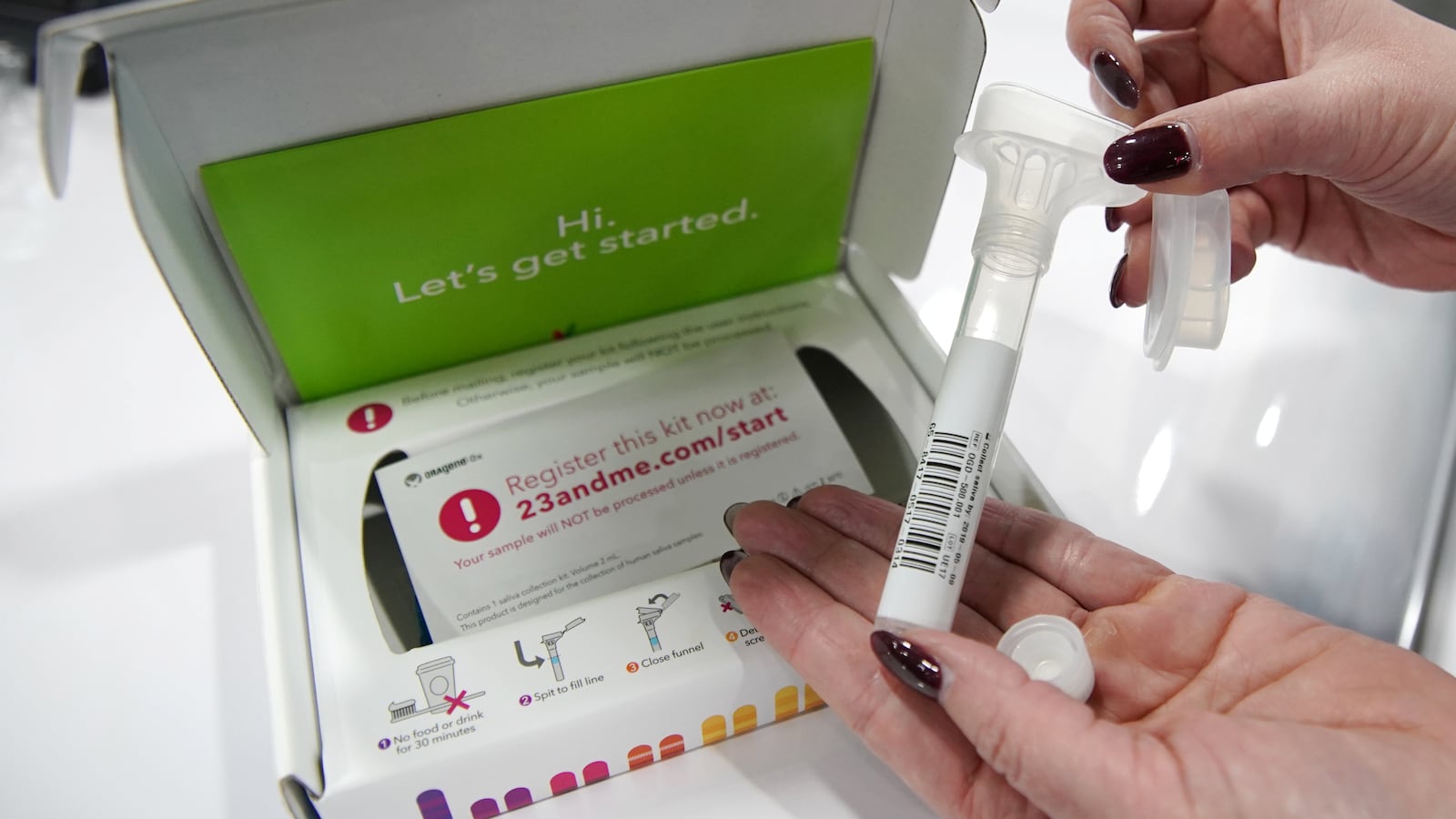 A company representative show off what is in a DNA kit at the 23andMe booth at the RootsTech annual genealogical event in Salt Lake City, Utah,