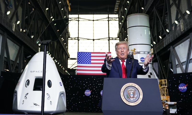 President Donald Trump speaks near a SpaceX Crew Dragon capsule at a press briefing after the launch of the SpaceX Falcon 9 rocket and Crew Dragon spacecraft on NASA's SpaceX Demo-2 mission to the International Space Station from NASA's Kennedy Space Center in Cape Canaveral, Florida on May 30, 2020.