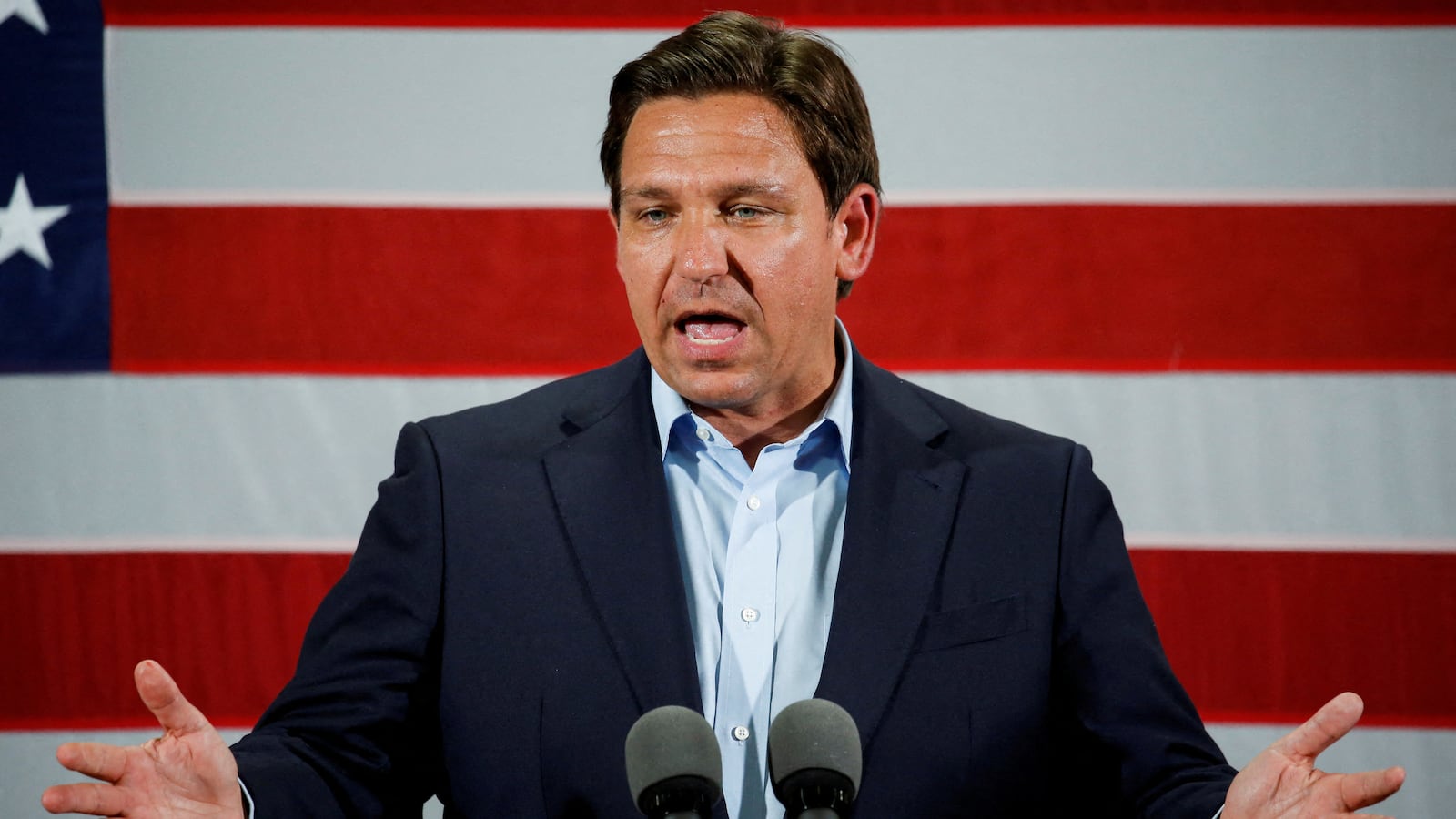 Ron Desantis gives a speech in front of an American flag.